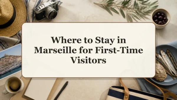 Overhead Marseille travel flat lay with a Vieux-Port harbor photograph, camera, straw hat, olives, coffee, fish, and a blank notebook around a central title card.