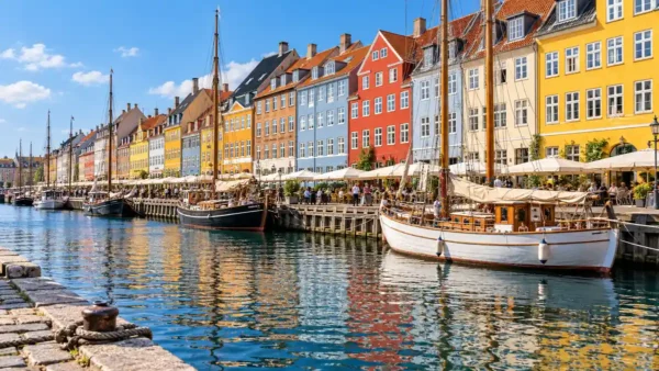 Travel to Copenhagen, Denmark: How to Plan Your First Trip 9 Colorful Nyhavn townhouses and wooden boats reflected in the Copenhagen canal