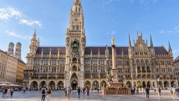 Things to Do in Munich: Which Sights Are Worth Your Time 11 The neo-Gothic New Town Hall overlooks Marienplatz in Munich, with small groups of visitors crossing the square.