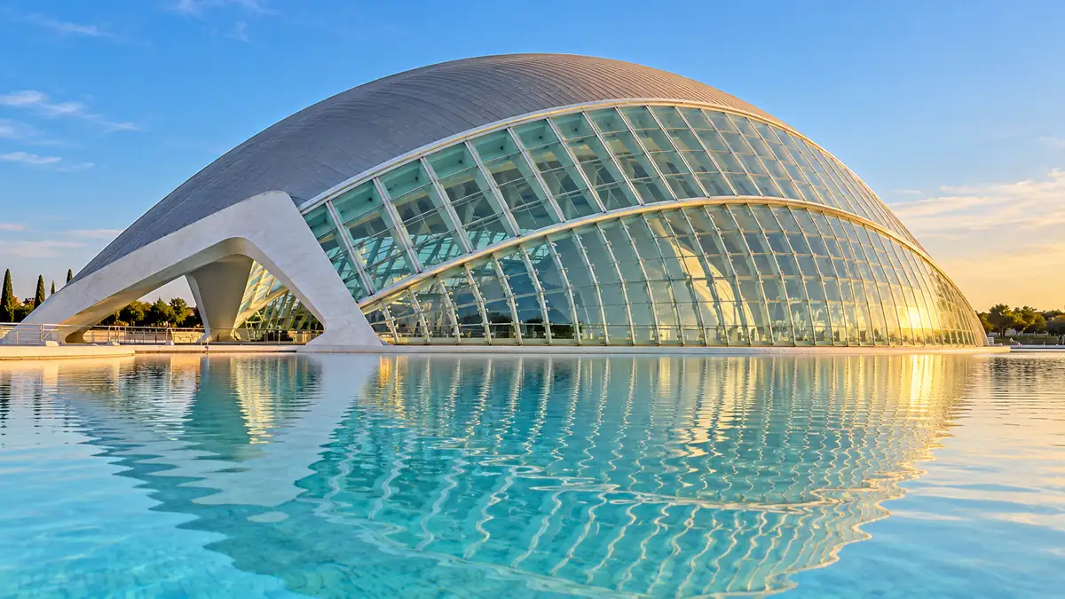 Travel to Valencia, Spain: How to Plan Your First Trip 2 White curved Hemisferic building reflected in turquoise water at Valencia's City of Arts and Sciences.